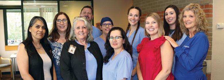 卫生区家庭牙科诊所工作人员微笑着站在诊所大厅的照片